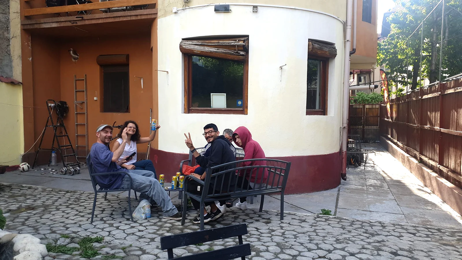 Grup școlar stând în curtea Popcorn Hostel din București, după sosire