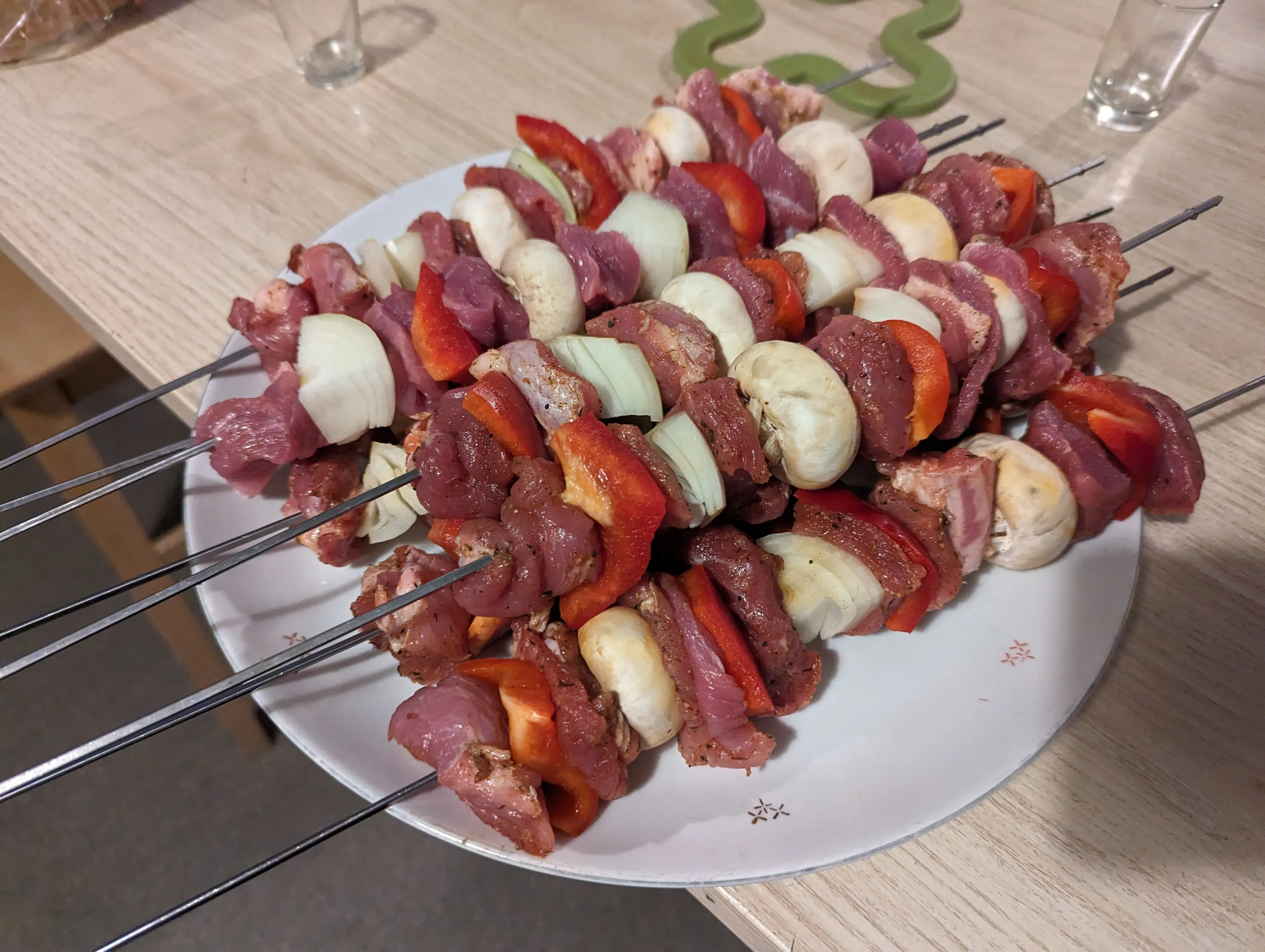 Brochettes crues pour le barbecue avec porc, poivrons et oignons, sur la table de l'espace commun du Popcorn Hostel.