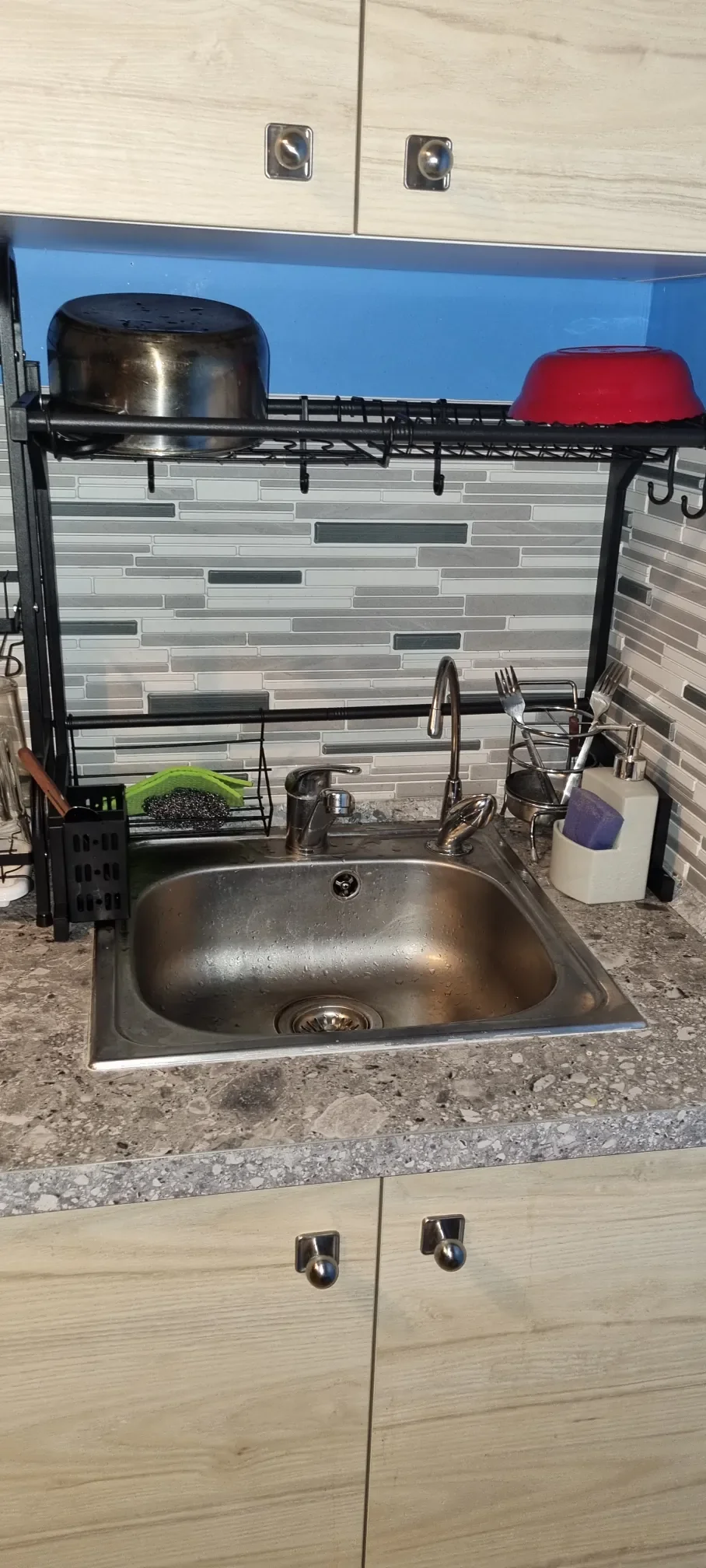 Lavello in acciaio e scolapiatti nero sospeso nella cucina condivisa del Popcorn Hostel a Bucarest.