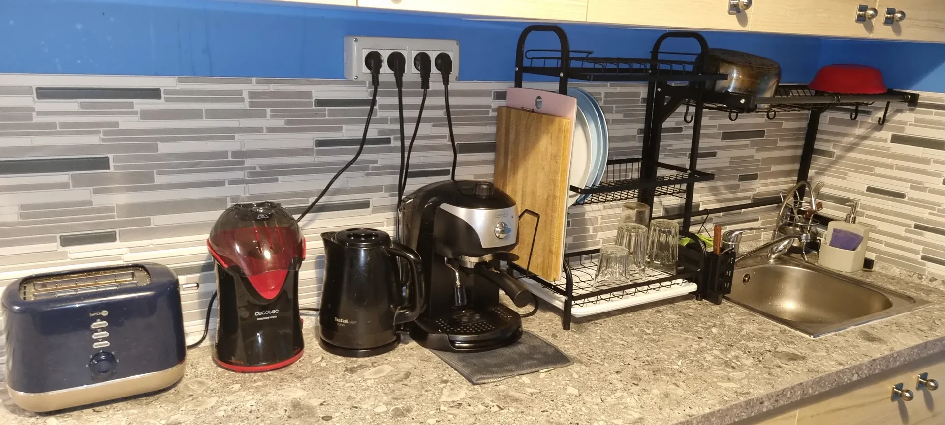 Bancone cucina con tostapane, bollitore e macchina espresso nella zona comune del Popcorn Hostel Bucarest.