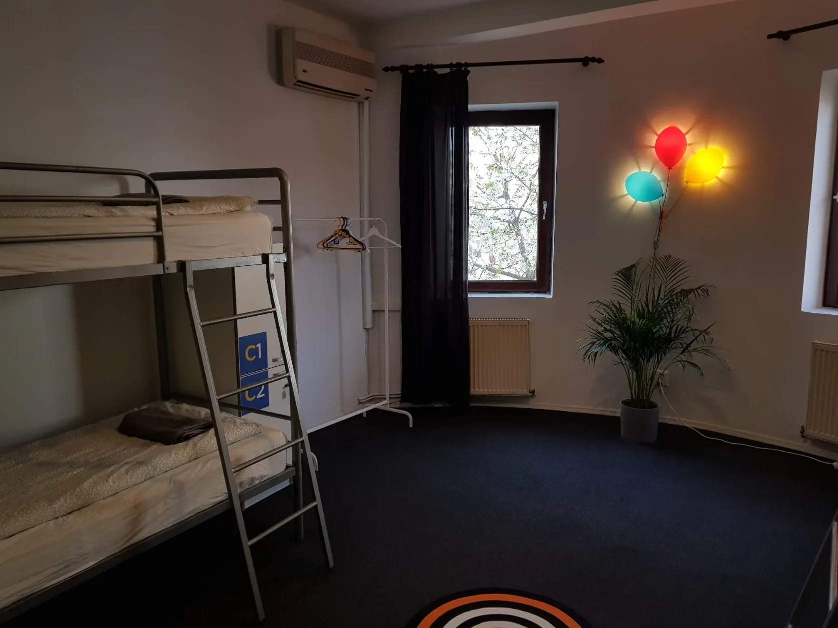 Camerata con lampada a forma di palloncini colorati, aria condizionata e armadietti C1-C2 al Popcorn Hostel.