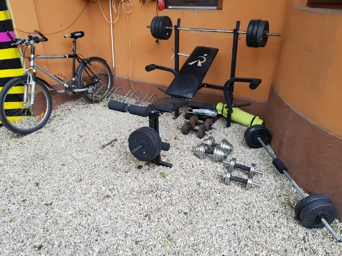 Palestra improvvisata nel cortile del Popcorn Hostel: panca pesi, bilancieri, manubri e una bicicletta.